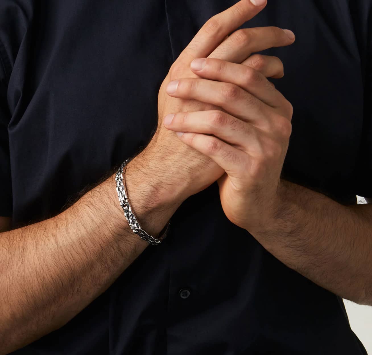 Mann mit silbernem Armband, schwarzes Hemd.