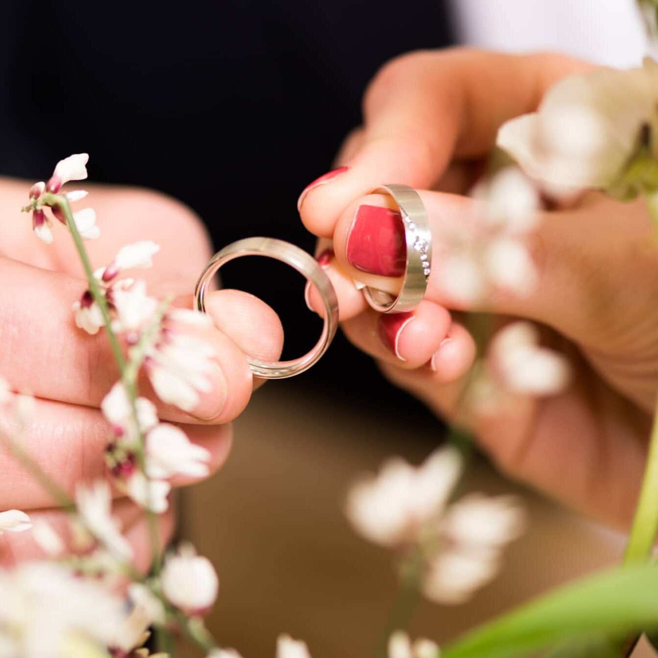 nos bagues fiancailles et alliances Mains tenant délicatement des alliances fleuries